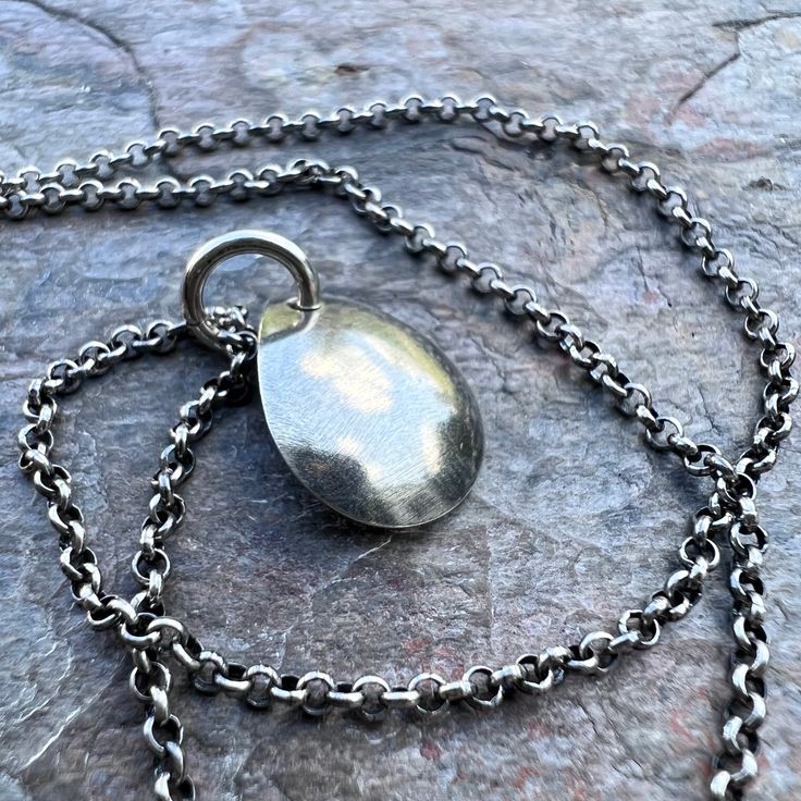 A small simple teardrop has been cut from a sheet of pure sterling silver. The teardrop was then slightly domed to give it a rounded shape. Pendant hangs from a sterling silver 1.75mm chain. The end of the chain features a lobster claw clasp and a 3-inch extender chain allowing the necklace to be slightly adjustable in length.Be sure to see all photos and video for size and color reference. Teardrop measures about 12x15mm Select your desired finish and length when ordering. The necklace is shown Minimalist Teardrop Pendant Necklace With Polished Finish, Minimalist Polished Teardrop Pendant Necklace, Minimalist Polished Finish Teardrop Pendant Necklace, Teardrop Pendant Necklace With Silver Chain, Minimalist Silver Teardrop Pendant Earrings, Minimalist Silver Teardrop Pendant, Teardrop Pendant Necklace With Polished Finish, Silver Teardrop Drop Necklace With Silver Chain, Silver Teardrop Pendant For Gift