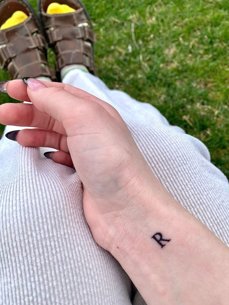 a person with a small tattoo on their left hand