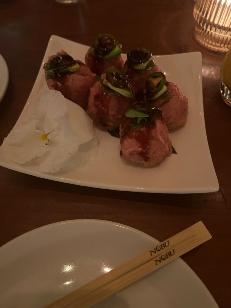 a white plate topped with meat and veggies on top of a wooden table