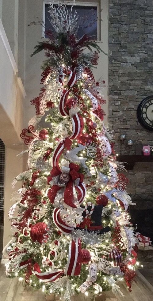 a christmas tree decorated with red, white and silver ribbons