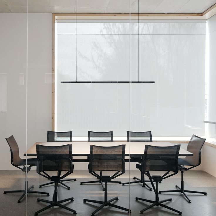 an empty conference room with black chairs and white walls