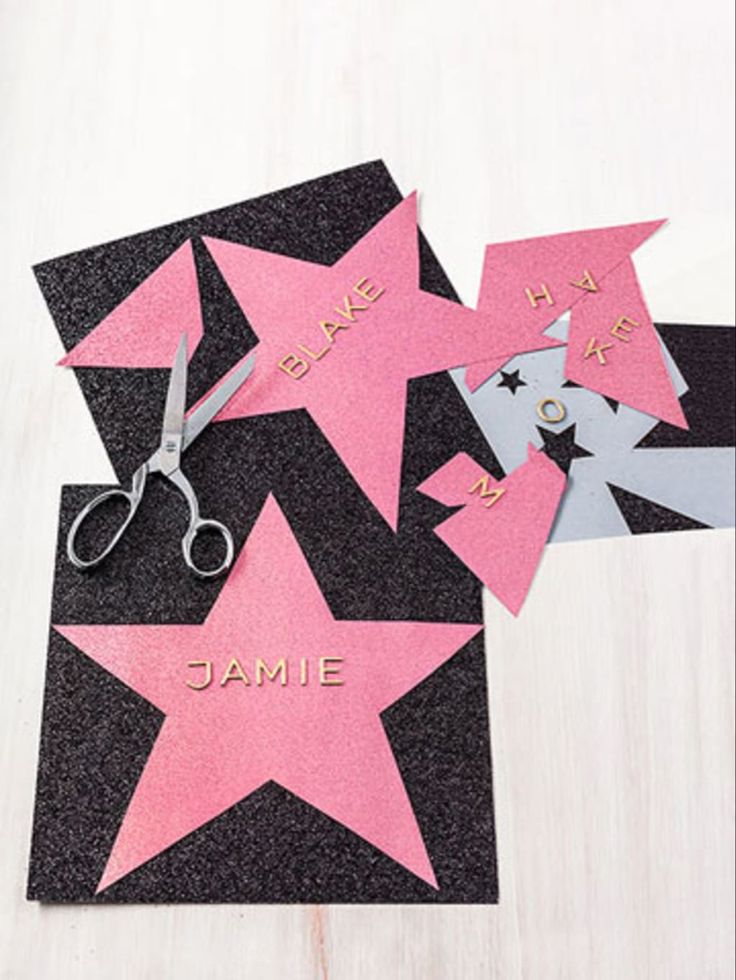 some pink and black paper cut out to look like stars with the name jamie on them