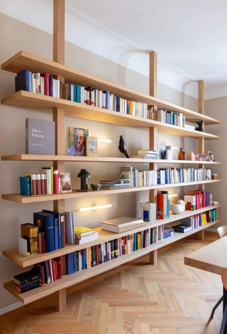 a bookshelf filled with lots of books on top of wooden shelves