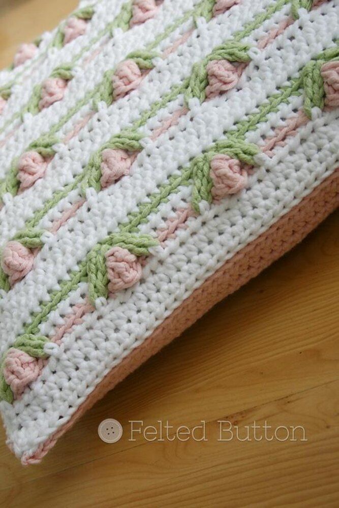 a crocheted pillow sitting on top of a wooden table