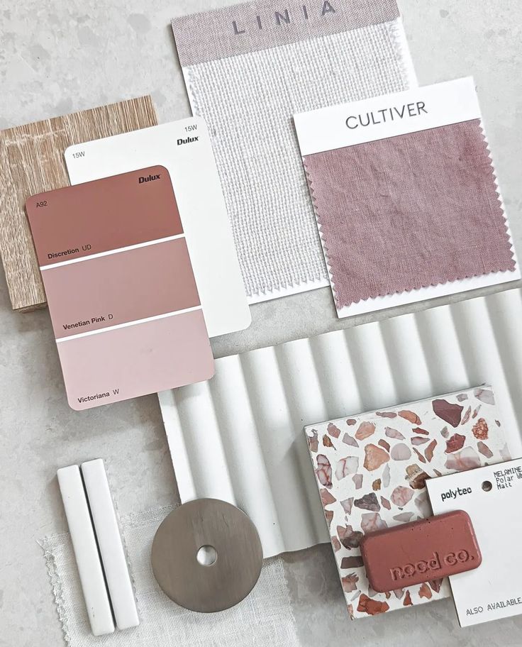 some paint swatches and other items on a white table with pinks, browns, and greens