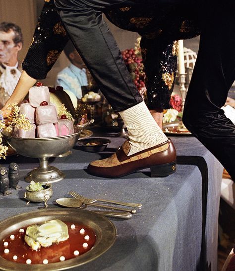 a man standing on top of a table next to other people