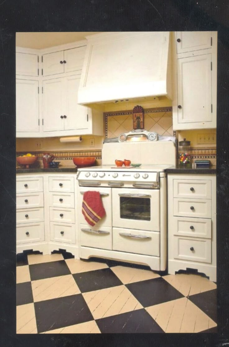 a kitchen with white cabinets and black and white checkered flooring on the floor