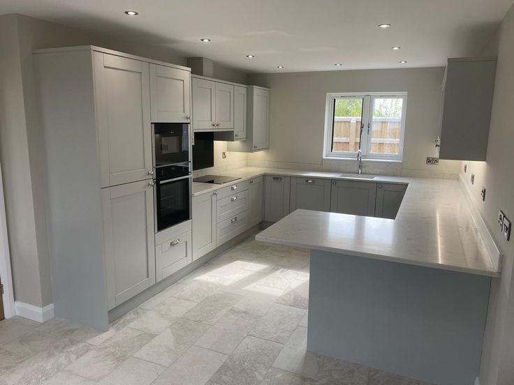 an empty kitchen with stainless steel appliances and marble counter tops, is pictured in this image