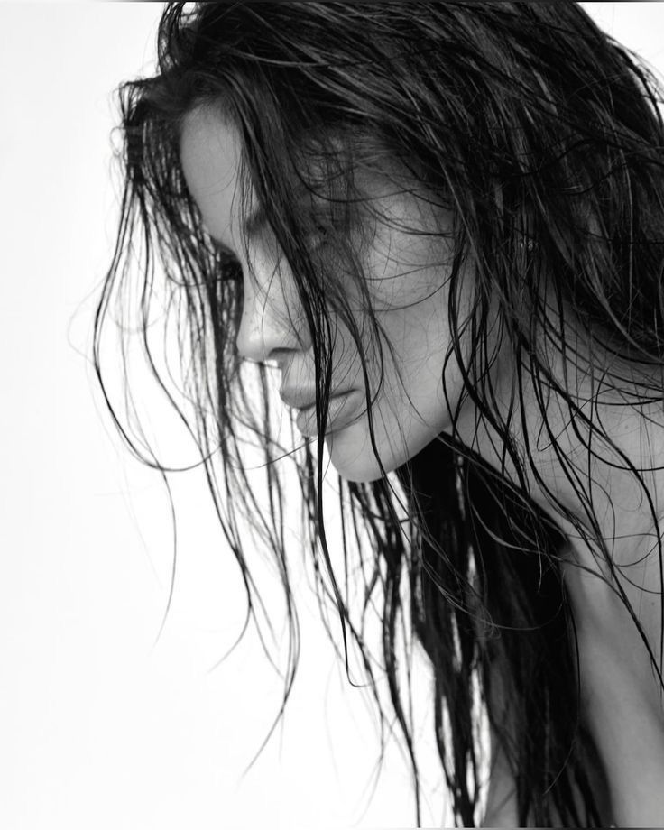 a black and white photo of a woman with wet hair