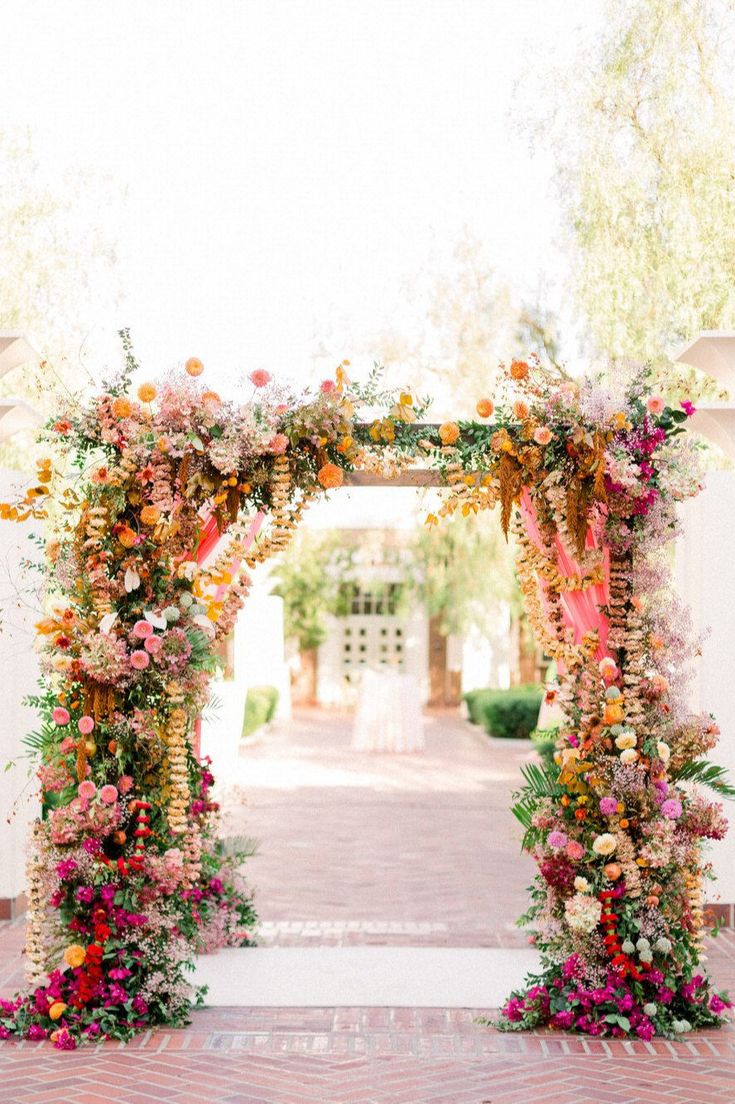 an archway decorated with flowers and greenery