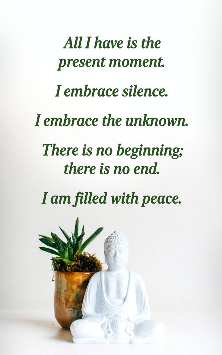 a buddha statue sitting next to a potted plant on top of a white table