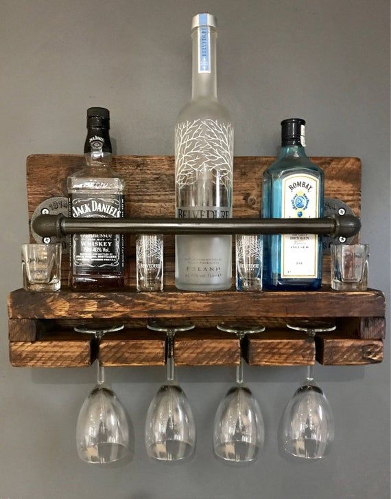 a wooden shelf with wine glasses and liquor bottles on it, hanging from the wall