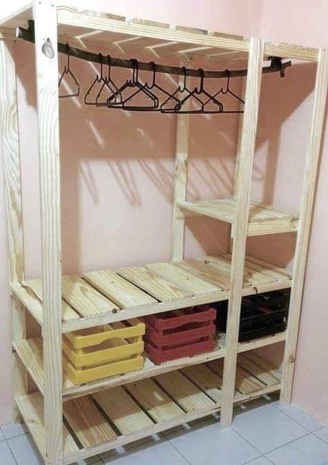 a wooden shelf with clothes hanging from it's sides and two baskets on the bottom