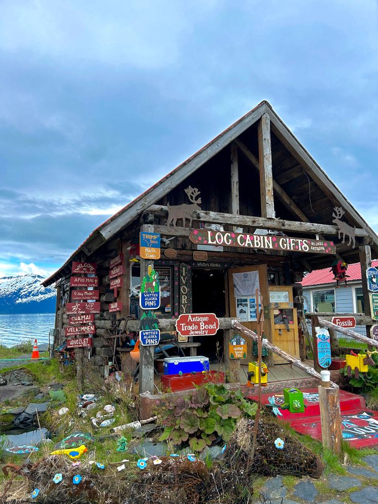 an old log cabin with lots of signs on it