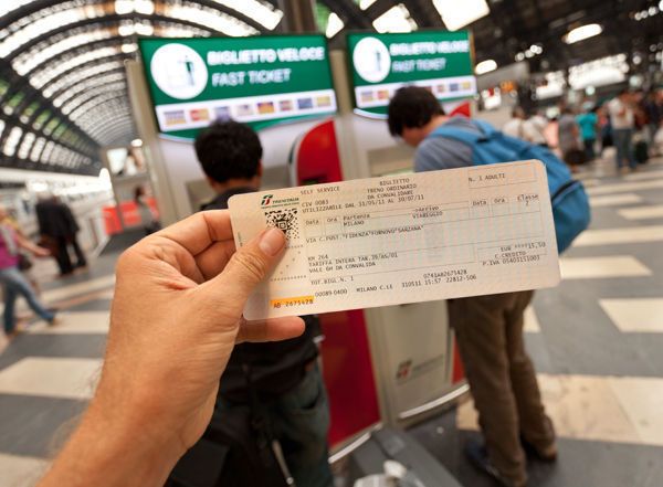 a person holding up a ticket at an airport