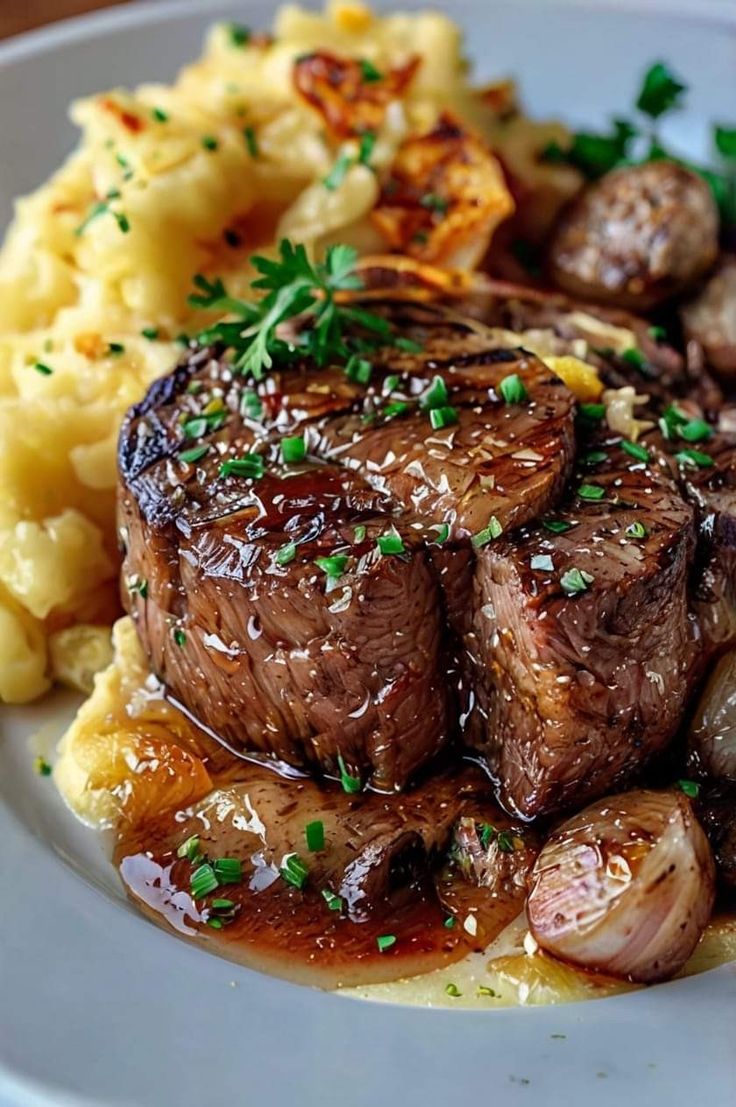 a white plate topped with steak, potatoes and gravy