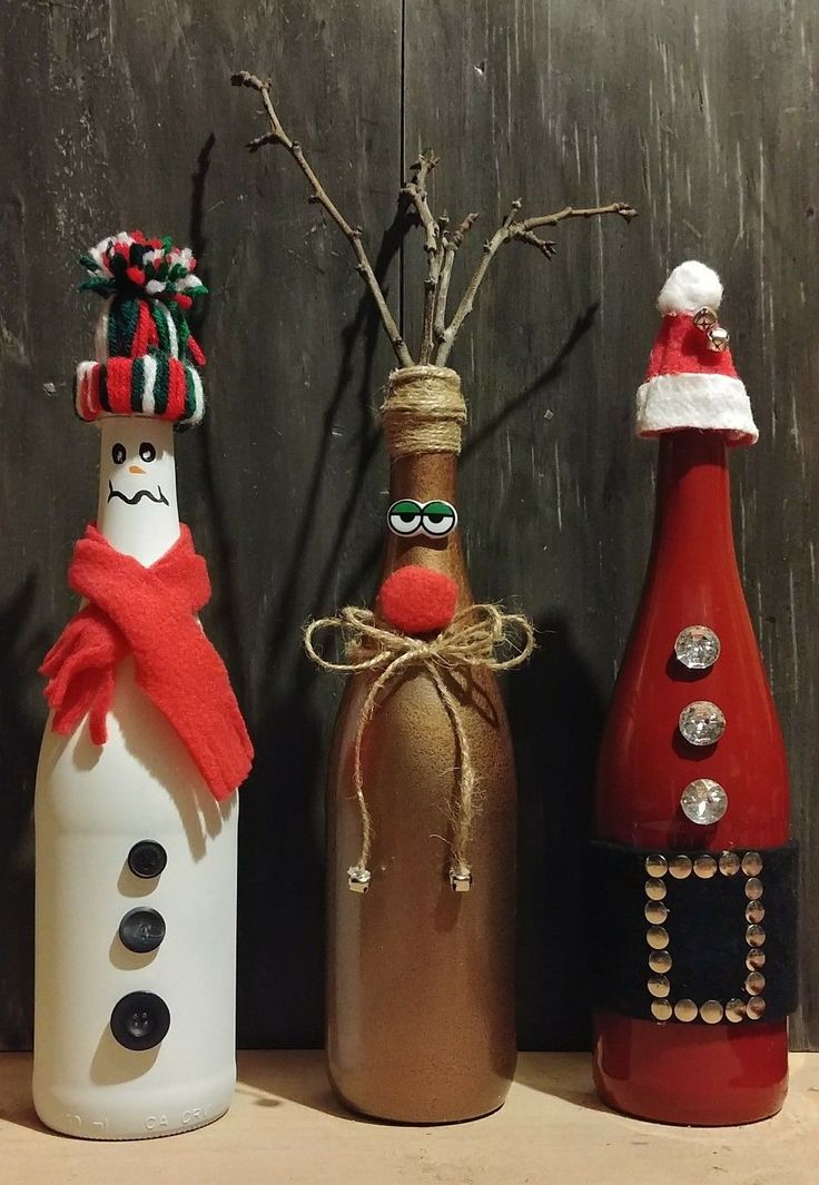 three wine bottles decorated like santa claus and snowman, one with a red scarf