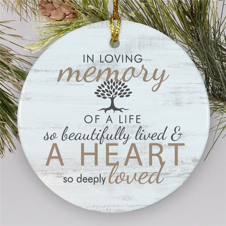 a white ornament with the words in loving memory and a tree on it