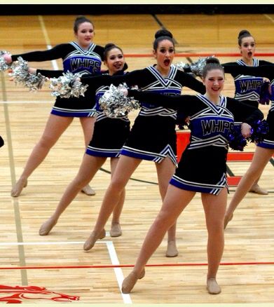 a group of cheerleaders performing on a basketball court