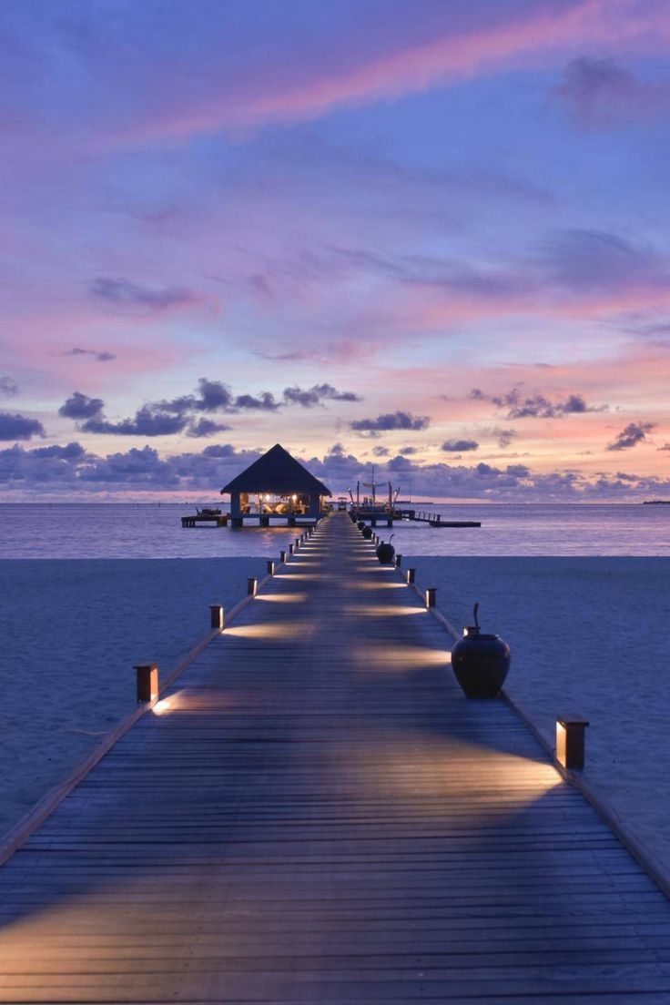 a long pier with lights on it at dusk