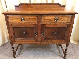 an old wooden dresser with two drawers on one side and some knobs on the other