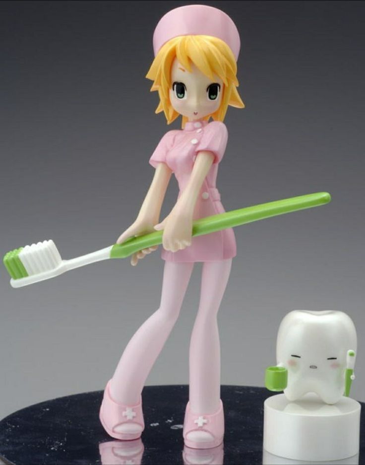 a figurine is holding a toothbrush in her hand and standing next to an object