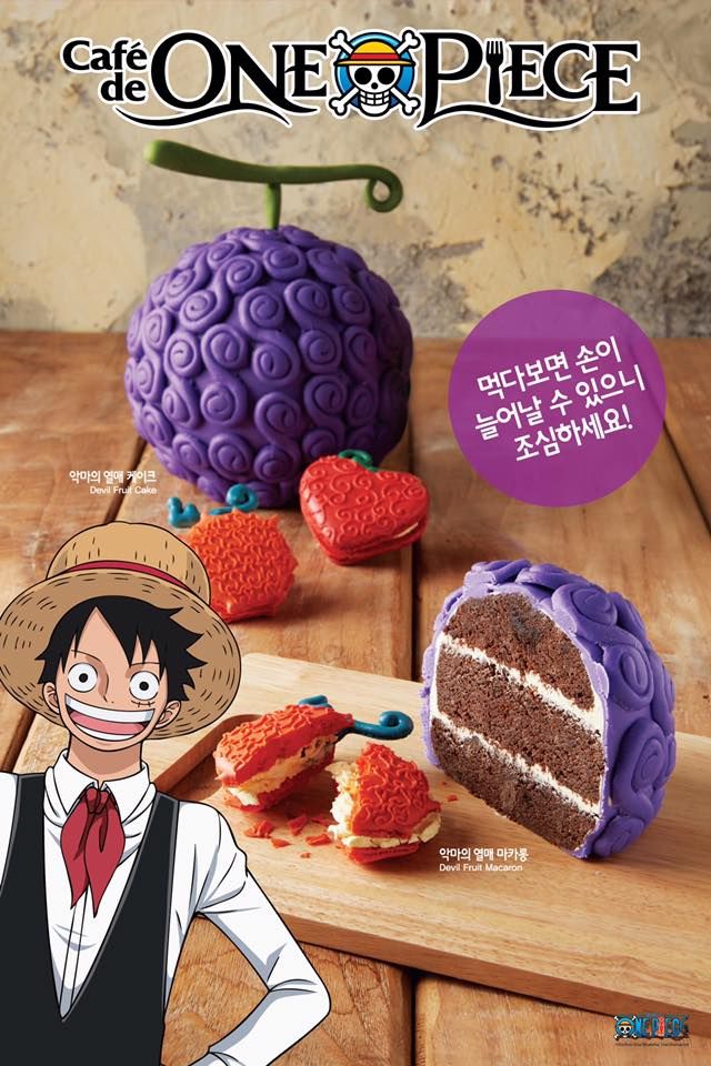 an advertisement for the one piece anime is displayed on a wooden table with strawberries and cake