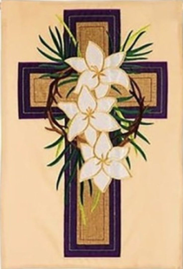 a cross with flowers on it is hanging from the side of a wall mounted banner