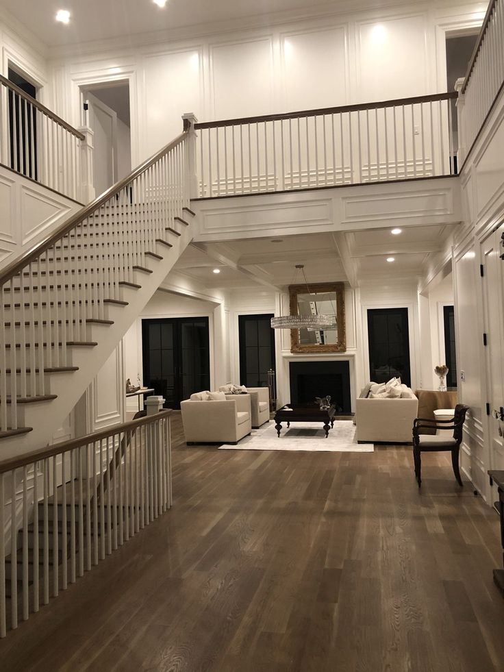 a living room filled with furniture and a fire place under a stair case next to a fireplace