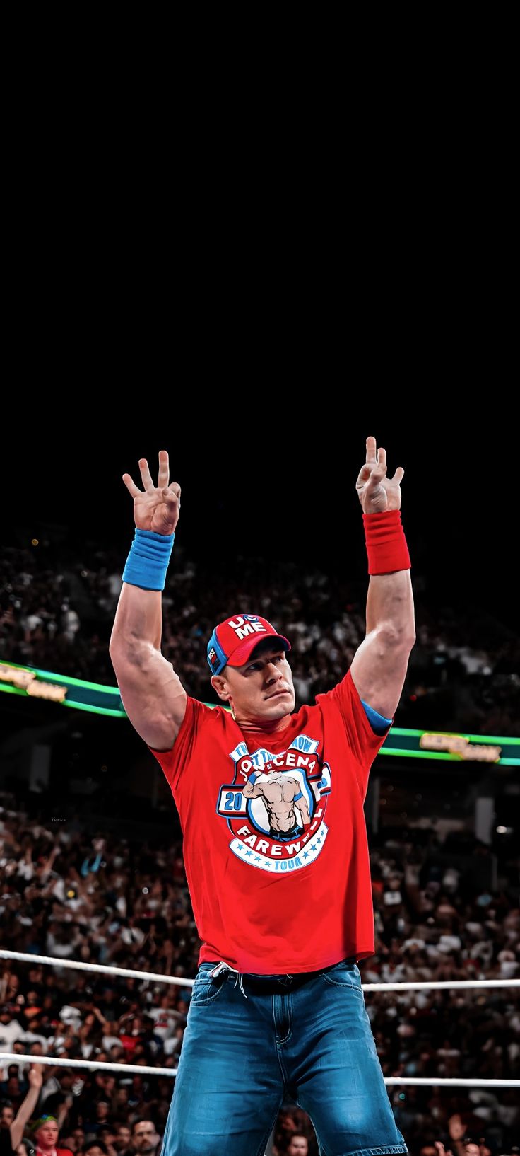 a man with his arms up in the air while standing on top of a wrestling ring