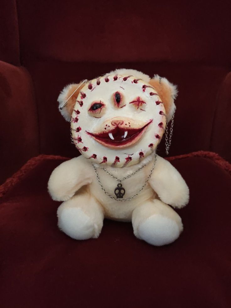 a stuffed animal that is sitting on a red chair with chains around it's neck