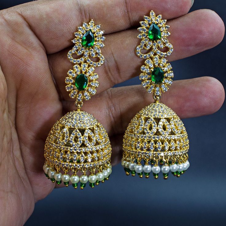 Experience the epitome of traditional Indian elegance with these exquisite 22K yellow gold plated CZ diamond crystal Nakshatra drop dangle Jhumka earrings. Crafted with meticulous attention to detail, these earrings feature a classic South Indian design that is perfect for ethnic occasions. The intricate patterns and sparkling crystals add a touch of glamour to any ensemble, making them a must-have accessory for every modern Indian woman. Lightweight and comfortable to wear, these earrings dangl Traditional Gold Jhumkas With American Diamond, Gold Chandbali Jhumkas With American Diamonds, Gold Temple Jewelry Style Danglers With American Diamond, Festive Gold Cubic Zirconia Earrings, Gold Chandbali Jhumkas With Cubic Zirconia, Gold Cubic Zirconia Chandbali Jhumkas, Traditional Gold Earrings With American Diamond, Traditional Gold Cubic Zirconia Danglers, Gold American Diamond Danglers