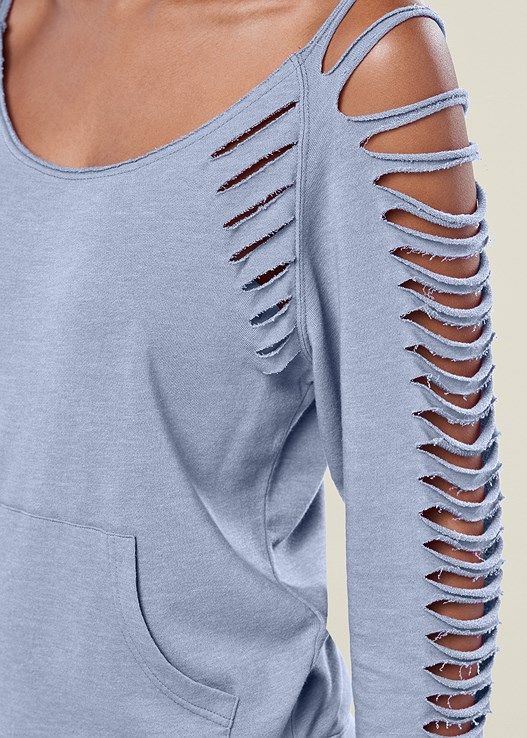 the back of a woman's blue top with cut out shoulders and long sleeves