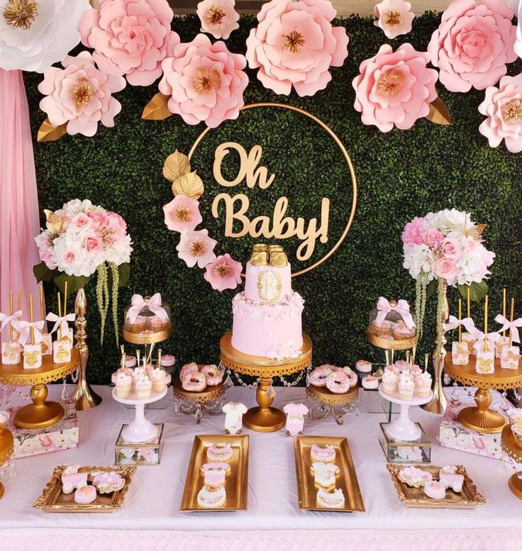 a baby shower party with pink and gold desserts, cake and cupcakes