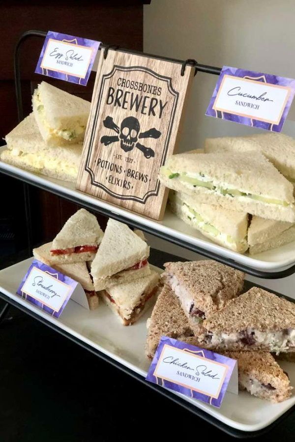 two trays with sandwiches on them sitting next to each other in front of a sign