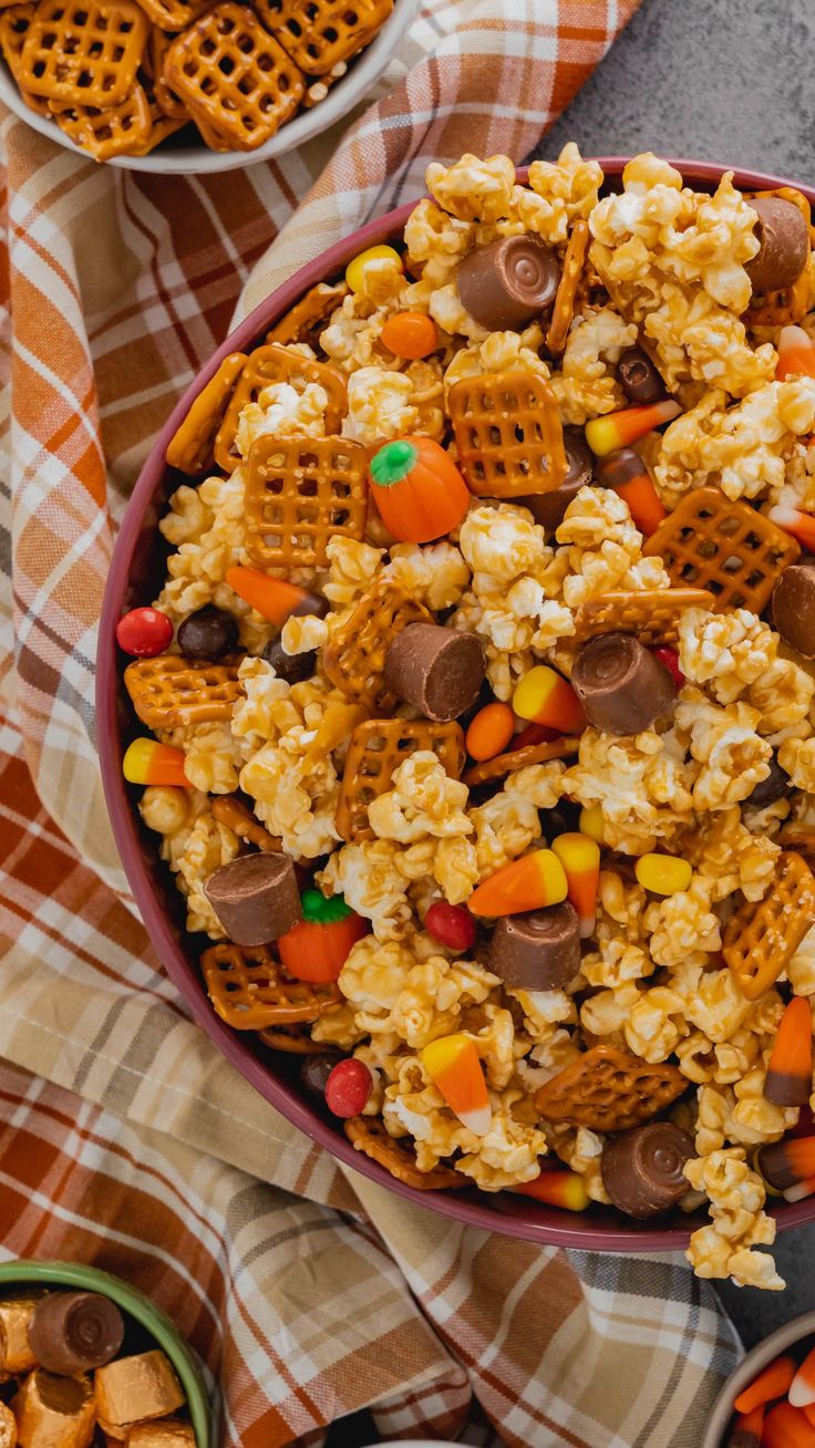 a bowl filled with cereal and candy corn on top of a checkered table cloth