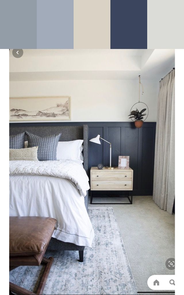 a bedroom with blue and white colors in the walls, carpeted flooring and an upholstered bed