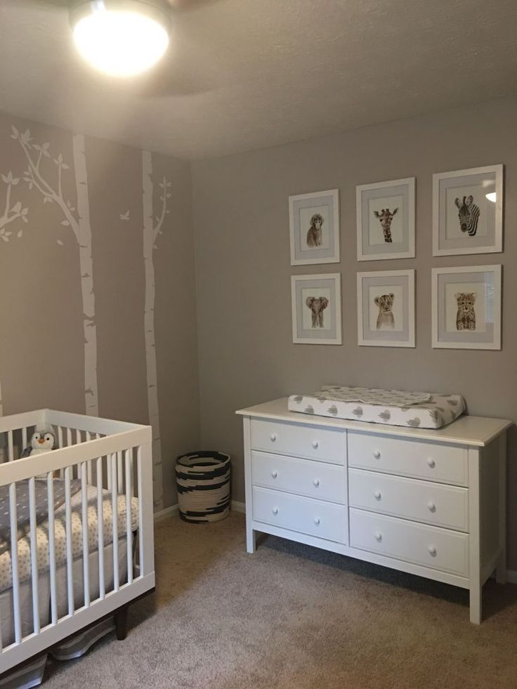 a baby's room with a crib, dresser and pictures on the wall