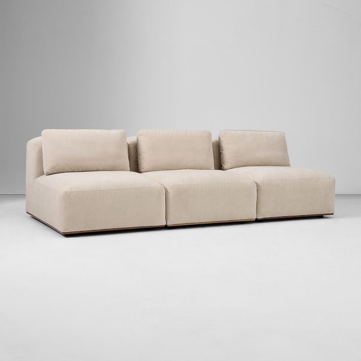 a beige couch sitting on top of a white floor