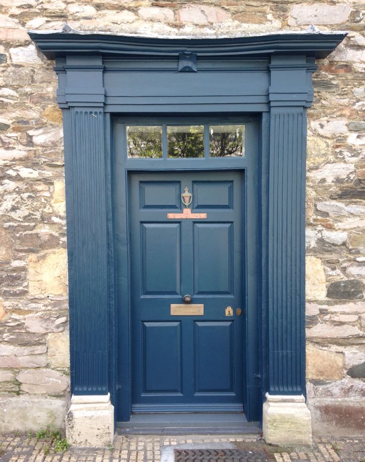 a blue door is on the side of a stone building