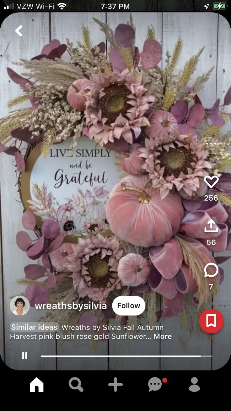 an image of a wreath with flowers and leaves on the front of a wooden wall