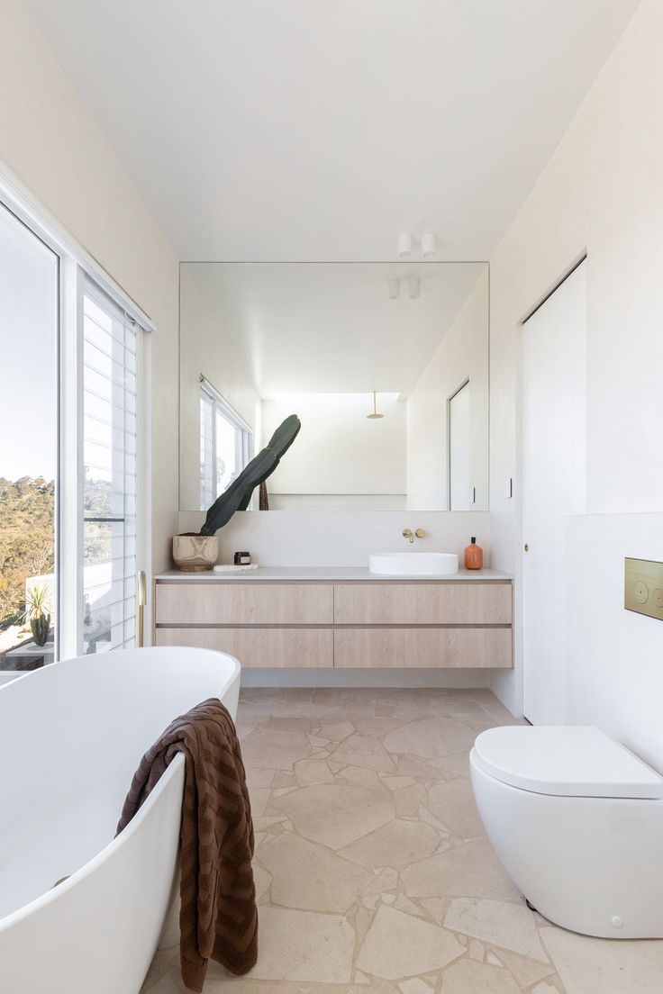 a bathroom with a large white tub next to a toilet