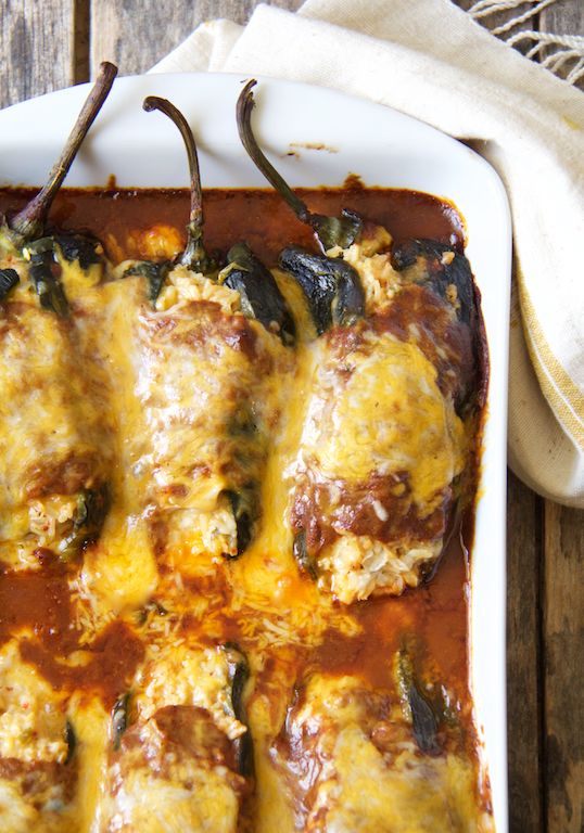 an enchilada casserole is shown in a white dish on a wooden table