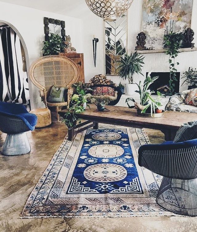 a living room filled with furniture and lots of plants on top of a wooden table