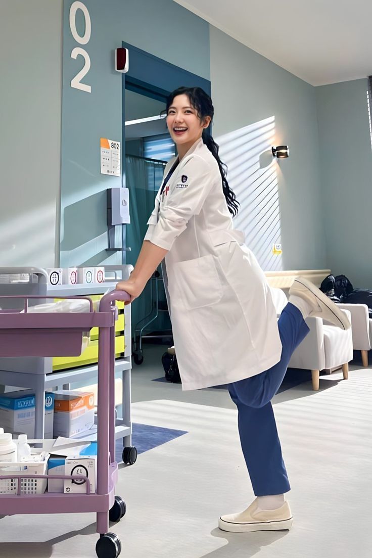 a woman in a lab coat is pushing a cart