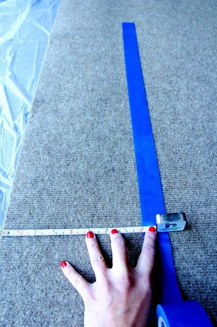 a woman's hand is measuring the length of a piece of blue tape