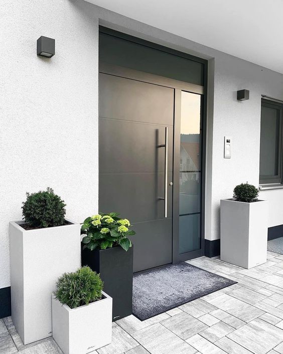 two planters with plants are in front of a door