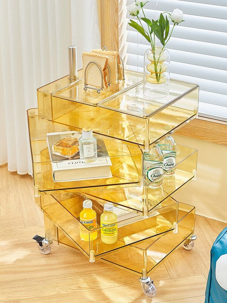 three tiered clear acrylic side table with bottles and soaps on it