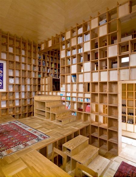 a room filled with lots of wooden shelves covered in bookshelves next to a rug