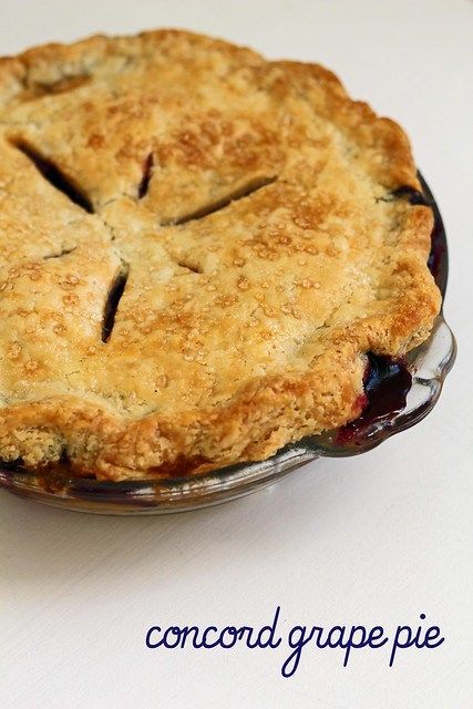 a blueberry pie in a glass dish on a white table top with the crust removed